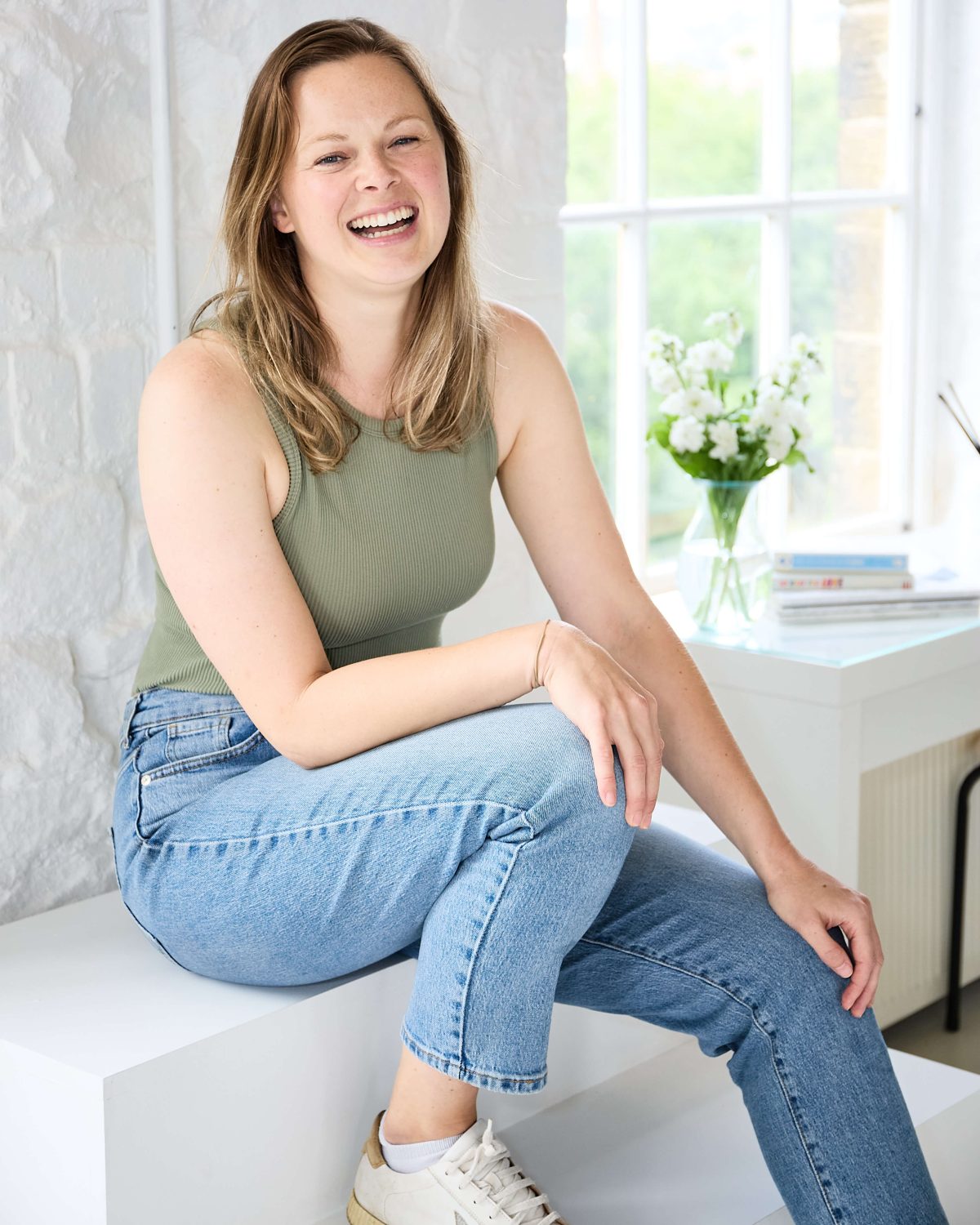 woman sat on steps in a studio in Nelson having her photo taken during a brand shoot